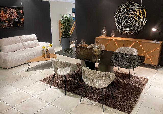 Canapé d’angle beige moelleux et design avec tables basses noires et blanches dans le showroom Mobilier de France Lanester